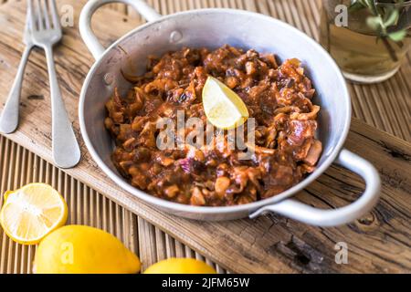 Anelli di calamari stufati in salsa di pomodoro per cena. Vista dall'alto. Foto Stock