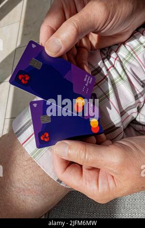 Primo piano di un uomo persona mani che tiene NatWest Bank carte di credito da visita carte di debito contactless Inghilterra Regno Unito Regno Unito Gran Bretagna Foto Stock