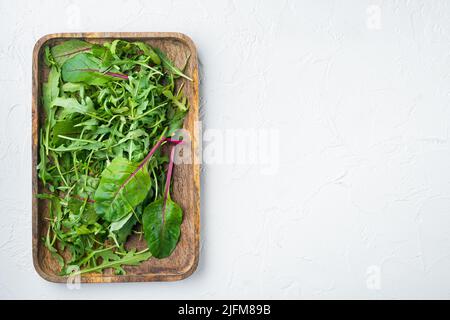 Rucola raab e Mangold, set di bietole svizzere, su sfondo di pietra bianca, vista dall'alto, con spazio per la copia del testo Foto Stock