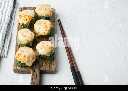Involtini di sushi giapponesi denominati EBI al forno con wasabi e pesce salmone, su sfondo di pietra bianca, con spazio per il testo e spazio per il copyspace Foto Stock