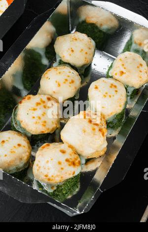 Sushi roll in contenitore da asporto, su sfondo in pietra nera Foto Stock
