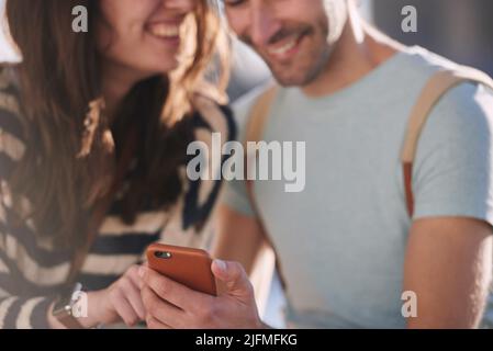 Niente ci collega più che condividere nuove avventure. Girato di una coppia irriconoscibile utilizzando uno smartphone mentre si esplora la città di Londra. Foto Stock