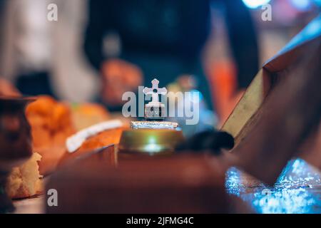 Ornamento con croce su un tavolo preparato per il battesimo di battesimo di battesimo di battesimo di battesimo di battesimo di un bambino in una chiesa. Foto di alta qualità Foto Stock