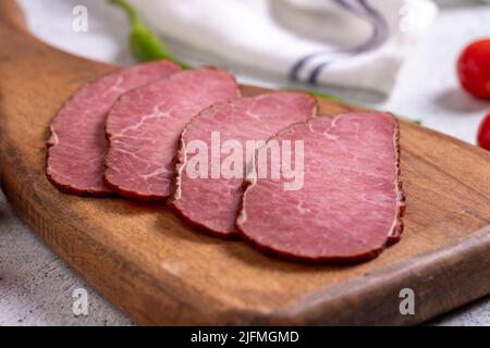 Pezzi di manzo a scatti. Fette di carne asciutta su un pavimento di pietra. Primo piano Foto Stock