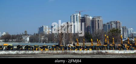 Kiev, Ucraina 18 marzo 2020: Trattori e escavatori in vendita sullo sfondo delle case in costruzione Foto Stock