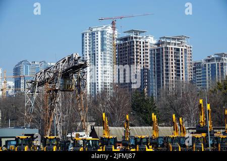 Kiev, Ucraina 18 marzo 2020: Trattori e escavatori in vendita sullo sfondo delle case in costruzione Foto Stock