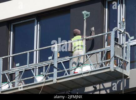 Kiev, Ucraina 18 marzo 2020: Lavoratori che finissano la facciata dell'edificio in culle sospese Foto Stock