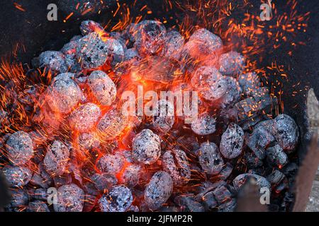 Calore che schiarisce da carbone incandescente per indurire i coltelli Foto Stock