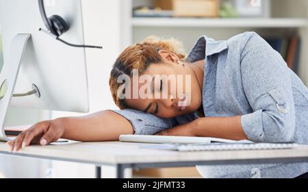 Un agente esausto del call center afroamericano che dorme in un ufficio. Donna d'affari che si sente sovraccaricato, stanco e demotivato durante il funzionamento Foto Stock