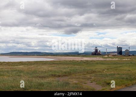 L'ex SSI altoforno visto da South Gare a Redcar, Inghilterra, Regno Unito con erba in primo piano Foto Stock