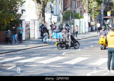 La gente si raduna intorno all'incrocio della zebra di fronte agli Abbey Road Studios di Londra. Foto Stock