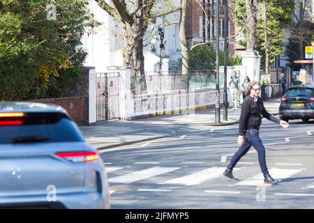 La gente si raduna intorno all'incrocio della zebra di fronte agli Abbey Road Studios di Londra. Foto Stock