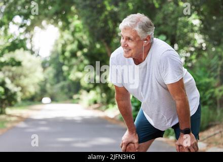 Mi piace molto la sfida. Scatto di un uomo maturo che cattura il suo respiro mentre si esercita all'aperto. Foto Stock