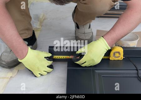 Misurazione della lunghezza del battente della porta per l'installazione successiva, porte scure all'interno. Foto Stock