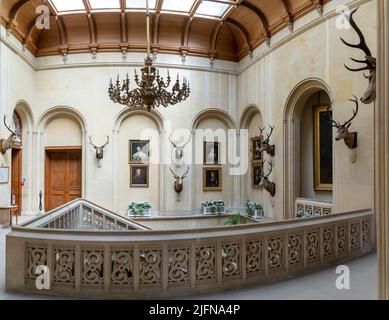 Golspie, Regno Unito - 25 Giugno, 2022: Vista interna del foyer e scala d'ingresso con dipinti e trofei di caccia nel castello di Dunrobin Foto Stock