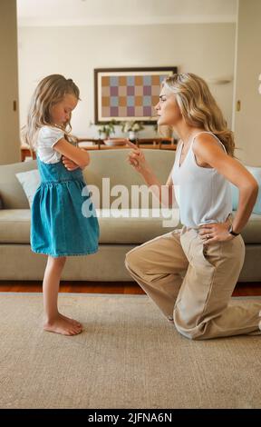 Giovane suora caucasica che scolava la sua figlia naughty in casa. Ragazza triste che solletta mentre è disciplinato da sua mamma per essere naughty dentro Foto Stock