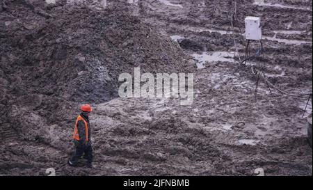 Kiev, Ucraina, 17 ottobre 2018: Lavoratori nel fango di un cantiere in fase di scavo; costruzione di un supermercato AUCHAN Foto Stock