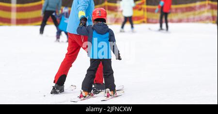 master class sci per bambini con istruttore nella scuola di sport invernali per bambini. Foto Stock