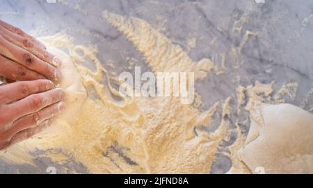 Pizzeria chef prepara la pizza tipica napoletana, semola e farine genuine su piano marmoreo presso la pizzeria di Napoli Foto Stock