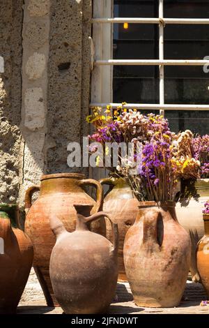 Vista su vecchie ceramiche storiche e tradizionali con fiori colorati. Opere di anfora fatte a mano catturate nella famosa città turistica egea chiamata al Foto Stock