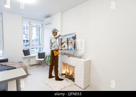 il padrone del riparatore tiene una tela della foto Foto Stock