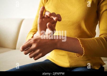 Adolescente ragazza che pratica EFT tocco o la tecnica di libertà emotiva a casa Foto Stock