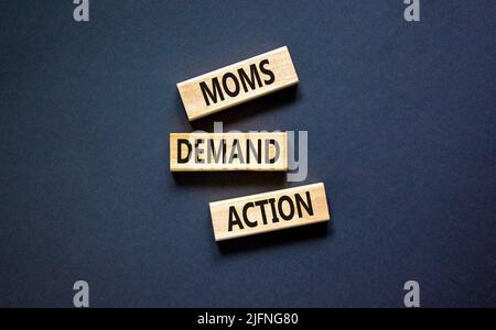 Simbolo di azione richiesta moms. Parole di concetto le mamme richiedono l'azione su blocchi di legno su uno sfondo nero bello tabella. Business, finacial e Moms Foto Stock