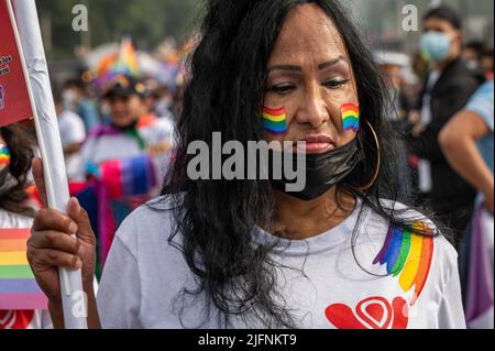 Foto di una donna con bandiere arcobaleno sul suo volto alla Marcha del Orgullo di Lima, l'evento annuale Pride march della città. Foto Stock