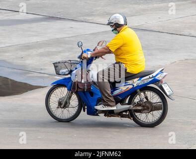 SAMUT PRAKAN, THAILANDIA, MAR 28 2022, un uomo con casco guida una moto sulla strada Foto Stock