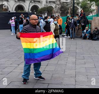 Foto di un uomo che posa con una bandiera arcobaleno a Plaza San Martin, il culmine della Marcha del Orgullo di Lima, l'evento annuale Pride march della città. Foto Stock