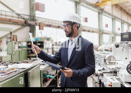 Responsabile tecnico che esegue il controllo di routine in fabbrica industriale Foto Stock