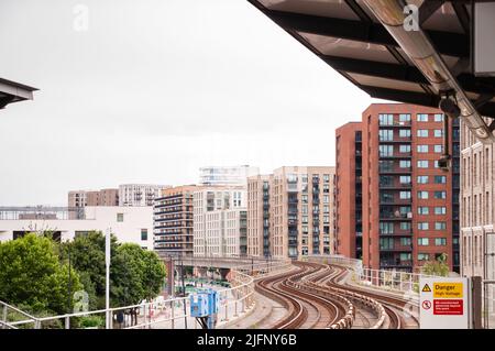 DLR Docklands Light Railway Train presso la West Silvertown Station di Londra. Treno DLR che arriva alla stazione in una giornata intensa Foto Stock