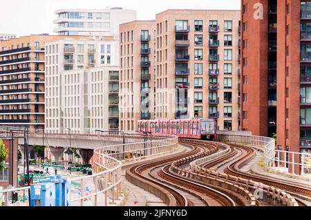 DLR Docklands Light Railway Train presso la West Silvertown Station di Londra. Treno DLR che arriva alla stazione in una giornata intensa Foto Stock