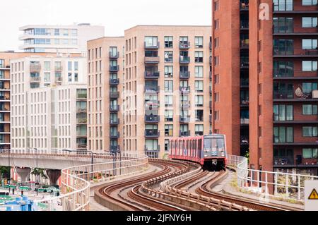 DLR Docklands Light Railway Train presso la West Silvertown Station di Londra. Treno DLR che arriva alla stazione in una giornata intensa Foto Stock