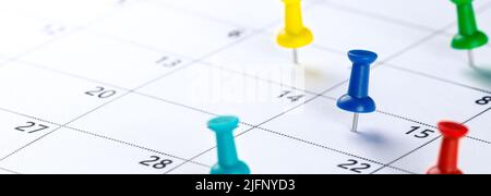 Pin a pressione colorati sul calendario che mostrano la pianificazione occupato - concetto di pianificazione aziendale Foto Stock