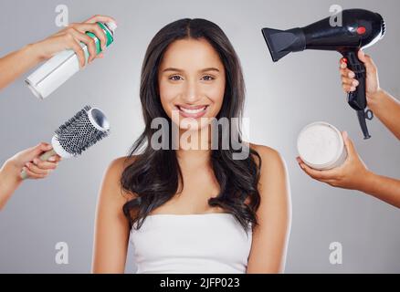Ottenere tutto dolled in su. Ritratto ritagliato di una giovane donna attraente che ottiene fatto backstage su uno sfondo grigio. Foto Stock