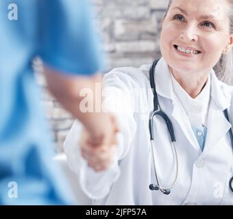 Grazie per avermi aiutato in questa procedura medica. Scatto di un medico che scuote le mani con un collega in un ufficio medico. Foto Stock