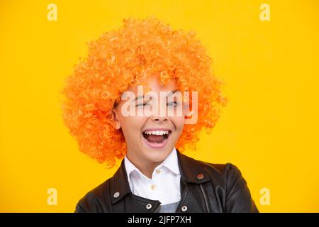 Faccia divertente. Bella ragazza adolescente in parrucca isolato sul giallo. Divertente clown wig. Foto Stock