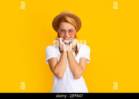 Ritratto sorridente di bella giovane donna che indossa occhiali da sole e cappello di paglia su sfondo giallo. Felice ragazza godendo l'estate. Foto Stock