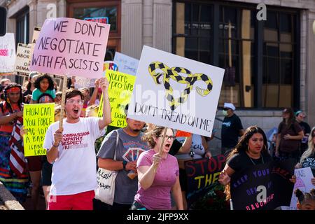 Bloomington, Stati Uniti. 04th luglio 2022. I manifestanti dei diritti di aborto hanno dei cartelli che esprimono la loro opinione durante una marcia di protesta prima della Parata del 4 luglio a Bloomington. Più di 100 attivisti per i diritti di aborto hanno partecipato a una marcia di protesta dopo che la Corte Suprema degli Stati Uniti ha abbattuto Roe contro Wade il 24 giugno 2022, che permetterà a stati come l'Indiana di criminalizzare completamente l'aborto. La legislatura dell'Indiana terrà una sessione speciale il 25th luglio. Credit: SOPA Images Limited/Alamy Live News Foto Stock