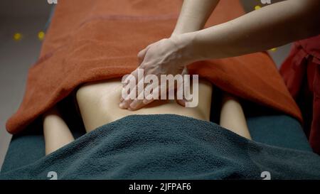 massaggiatrice che fa il massaggio profondo di una schiena femminile. Azione. Concetto di stile di vita sano e cura del corpo. Foto Stock