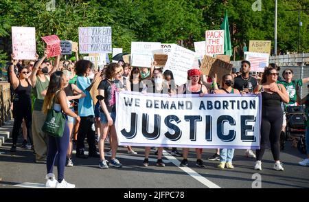 I partecipanti stanno tenendo una bandiera pro aborto prima di marciare sopra il ponte di Brooklyn a New York City per chiedere giustizia per l'aborto il 4 luglio 2022. Foto Stock