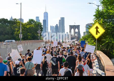 Centinaia di persone hanno dei cartelli mentre marciavano sul ponte di Brooklyn, New York City, per chiedere giustizia per l'aborto e altre questioni sociali il 4 luglio 2022. Foto Stock