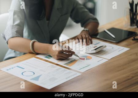 Primo piano mano donna d'affari usando il calcolatore per calcolare i risultati finanziari e il preventivo dell'azienda. Concetto di controllo account. Foto Stock