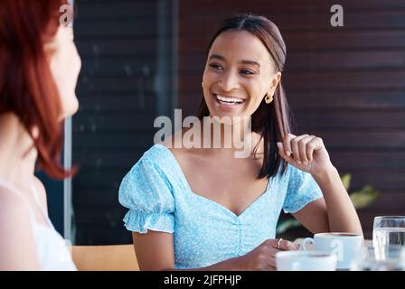 I fine settimana sono per passare del tempo con gli amici. Scatto di due giovani amici femminili che si ritrovano in un bar. Foto Stock