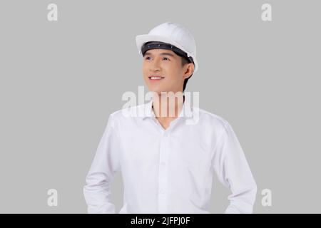 Ritratto giovane asiatico uomo è ingegnere indossare casco in piedi e sorridente con sicuro isolato su sfondo bianco, bello maschio è architetto o co Foto Stock