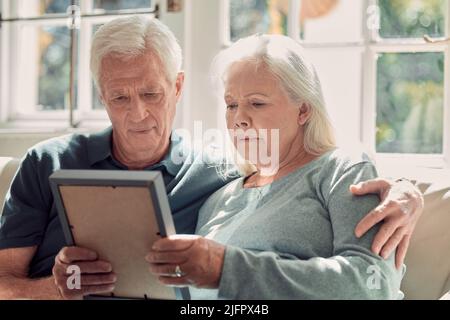 Quanto tempo fa era questo. Scatto corto di una coppia anziana affettuosa seduta nel loro soggiorno a casa. Foto Stock