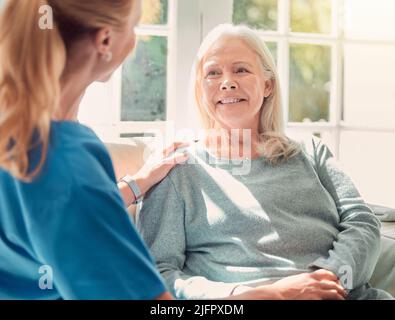 Non è mai troppo importante per aiutare gli altri. Shot di una donna anziana sostenuta dalla sua infermiera a casa. Foto Stock