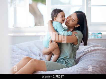 Possiamo fare i cuddles tutto il giorno. Scatto di una madre che si lega con il suo bambino a casa. Foto Stock