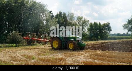 Trattore John Deere verde per aratura su stoppie. Foto Stock